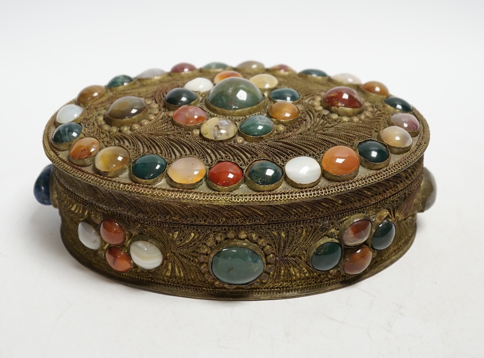 A brass filigree work and agate cabochon mounted oval box, 19cm wide